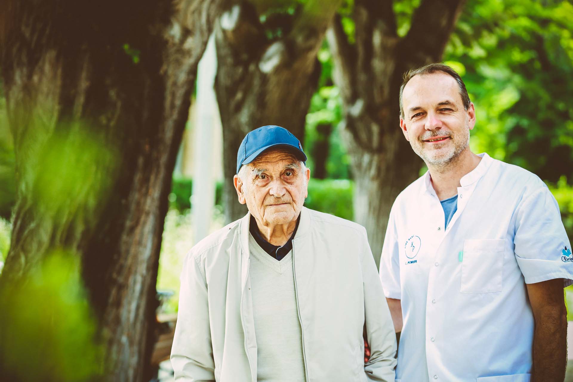 Un kinésithérapeute accompagne un résident de la résidence services seniors l'Orangerie du Château Levât. 